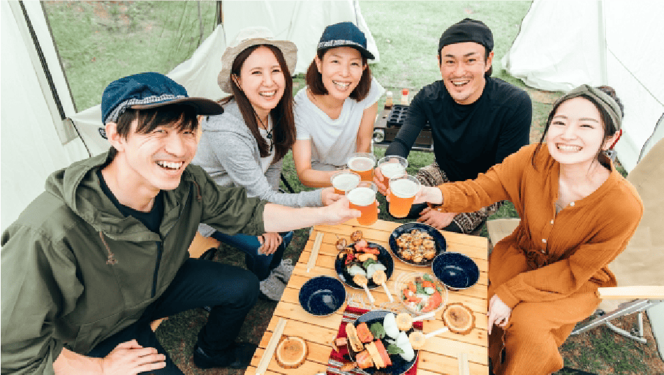 若者5人がキャンプ場で乾杯をしている様子